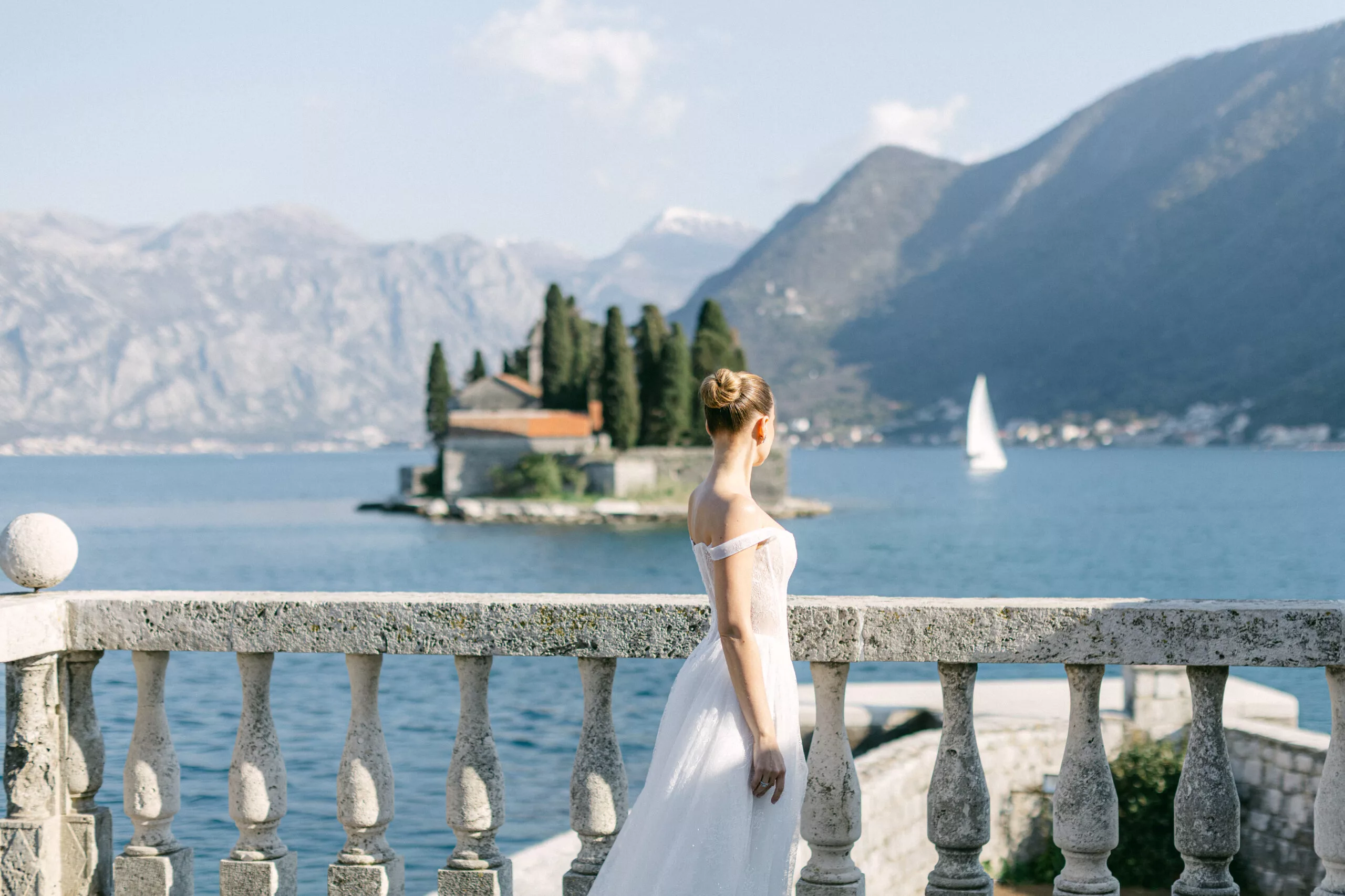 Bride on a villa balustrade overlooking Our Lady of the Rocks island
