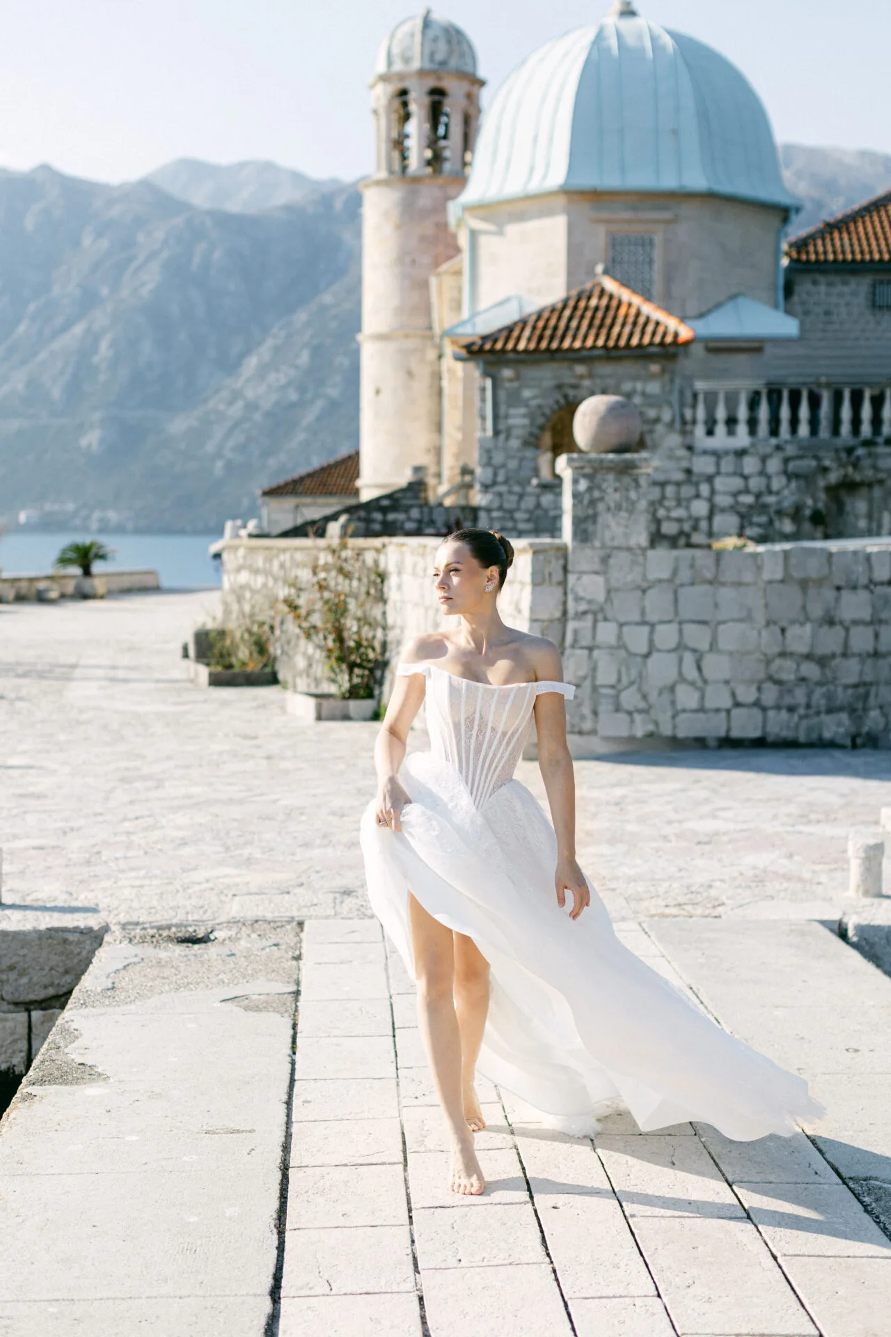 Bride in a white dress on the Perast waterfront