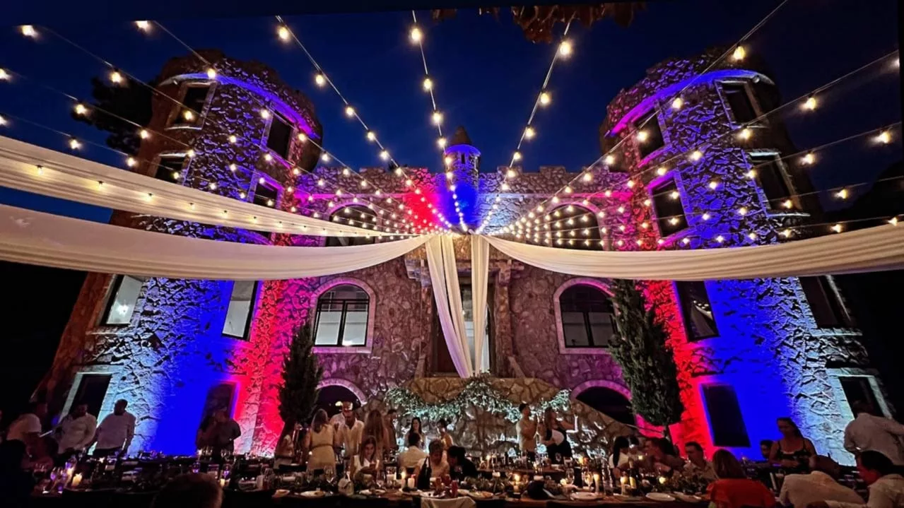 Evening reception in the courtyard of Kakela stone castle with festoon lights