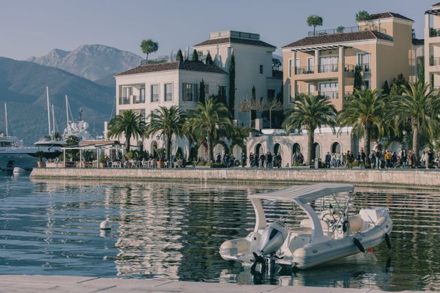 Motorboat on waterfront beside palm-lined buildings and mountains