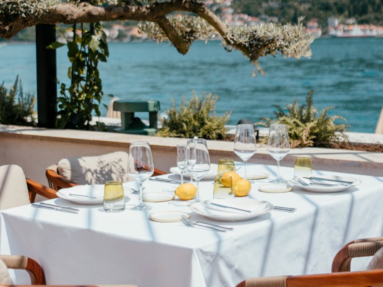 Elegant waterfront restaurant table set with wine glasses and lemons