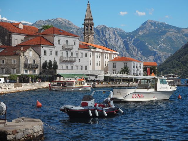 Boats on Kotor Bay beneath mountains and historic waterfront