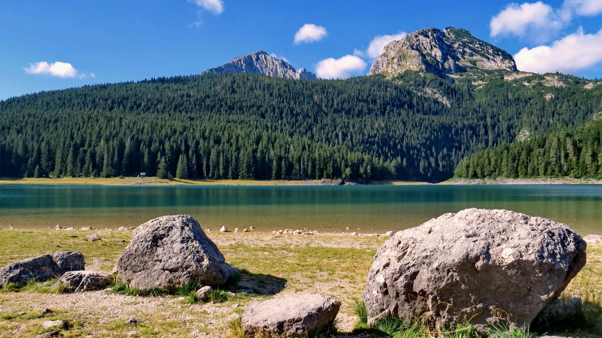 Black Lake in Durmitor with boulders, pine forest and mountain peaks